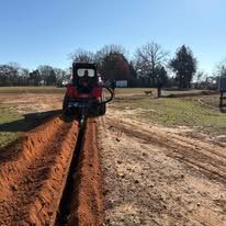 Skid steer trencher digging a long utility trench in Northeast Texas